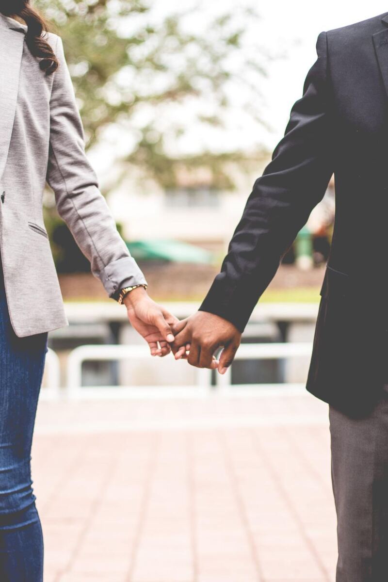 Couple holding hands, walking together outdoors